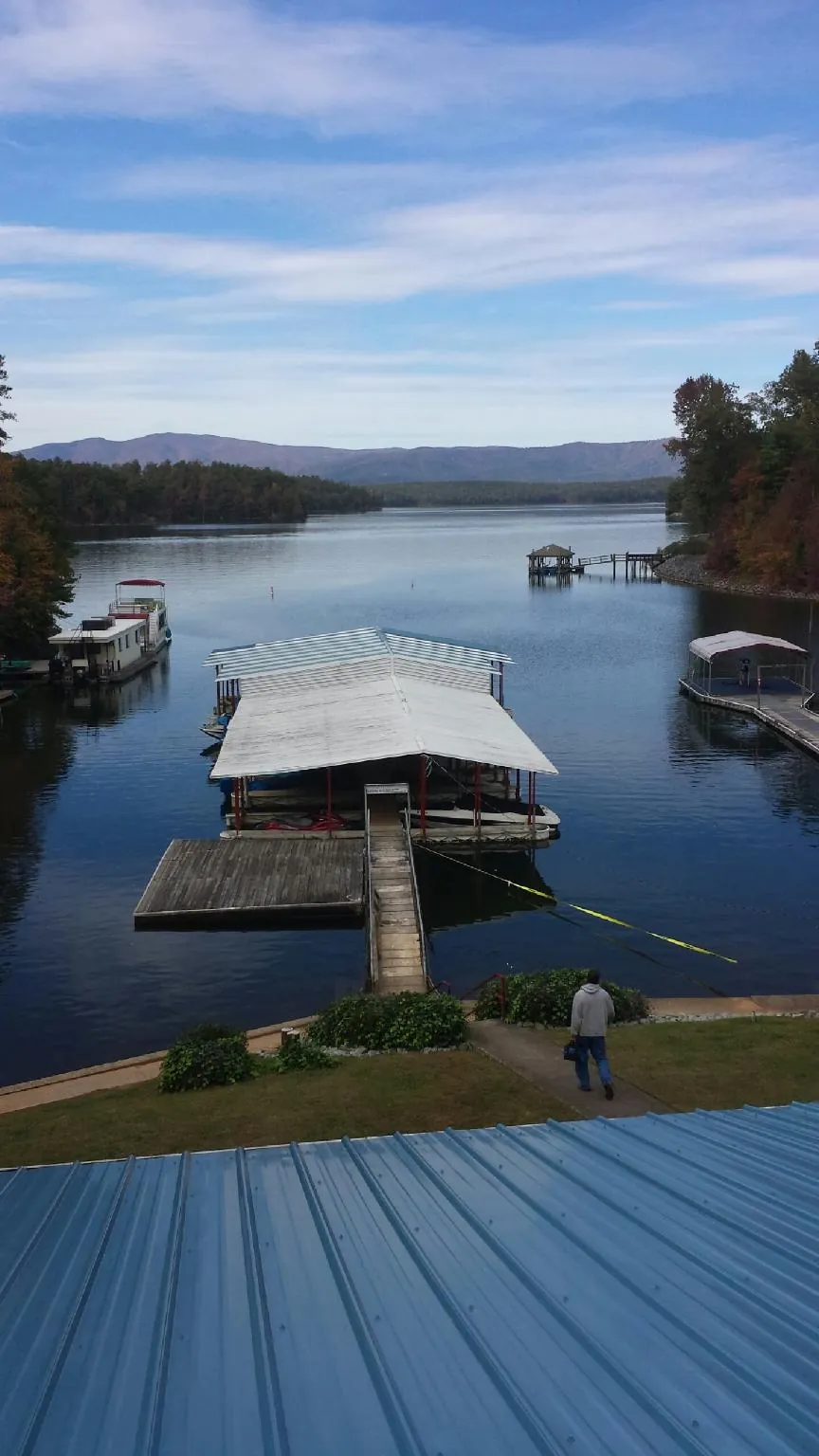 View across a lake from a newly installed blue metal roof in Grafton