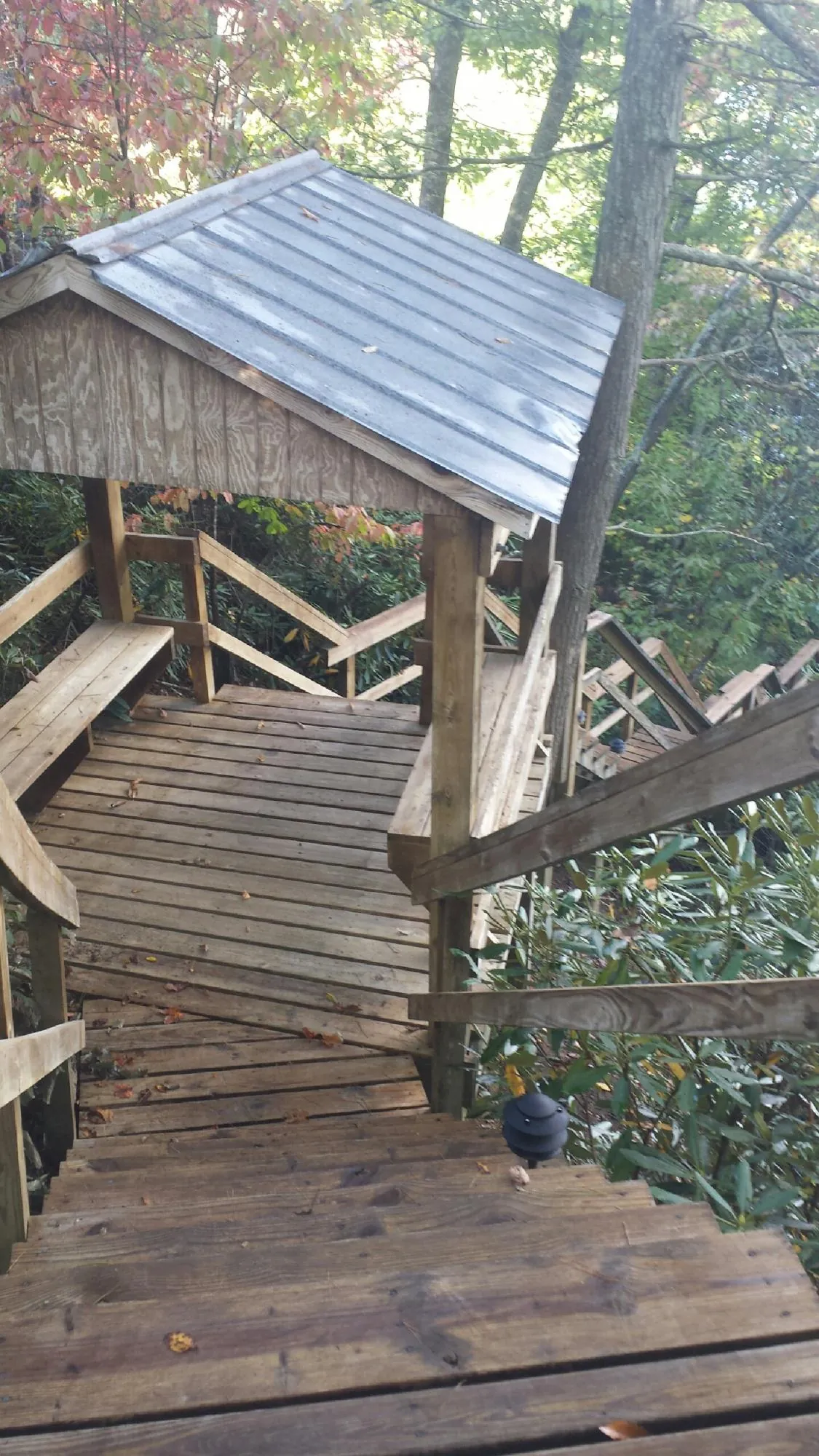 Metal roofed shelter over wooden steps on a wooded walkway — Skylight Repair & Installation work by our crew in Grafton